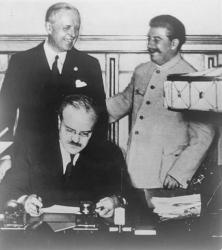 У присутності Йосипа Сталіна керівник МЗС СРСР В’ячеслав Молотов підписує так званий пакт Молотова — Ріббентропа  з нацистською Німеччиною. Москва, 23 серпня 1939 року. 