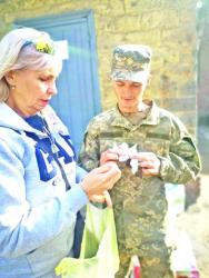 Наталія Костіна передає бійцю обереги, виготовлені малими прихожанами Свято-Миколаївського храму міста Полтави.