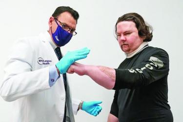 Лікар Едуардо Родрігес (зліва) перевіряє,  як прижилися пересаджені кисті у Джо Дімео.